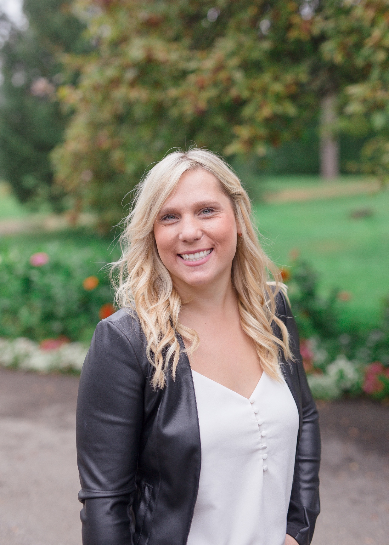 Bright outdoor portrait of a smiling business owner in a leather jacket
